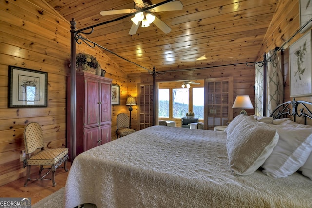 bedroom with vaulted ceiling, wood ceiling, a ceiling fan, wooden walls, and wood finished floors