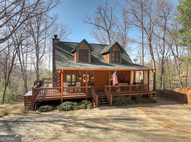 view of front of house featuring a chimney and log exterior