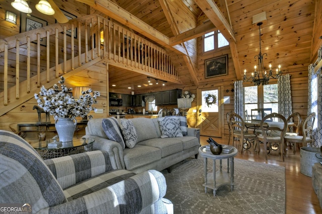 living area featuring wood walls, wood finished floors, a high ceiling, an inviting chandelier, and wooden ceiling