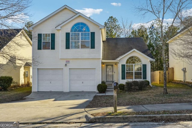 traditional-style house featuring fence, an attached garage, and concrete driveway