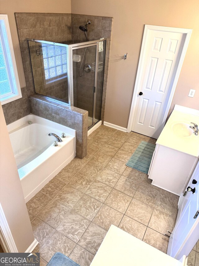 full bath with a sink, a shower stall, a garden tub, and tile patterned floors