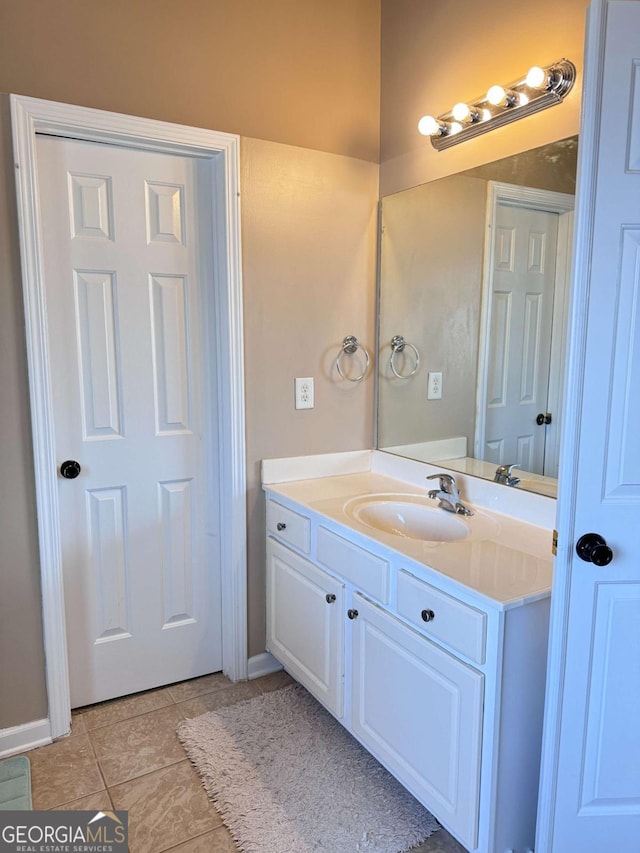 bathroom with vanity, baseboards, and tile patterned floors