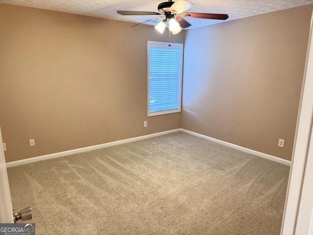 spare room with a ceiling fan, a textured ceiling, carpet, and baseboards