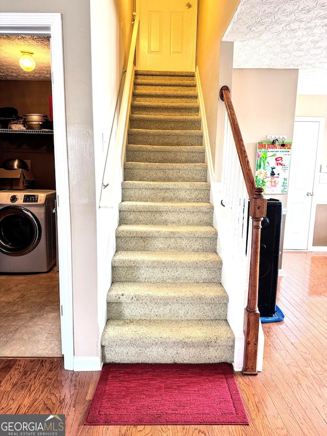 staircase featuring washer / clothes dryer, wood finished floors, and baseboards