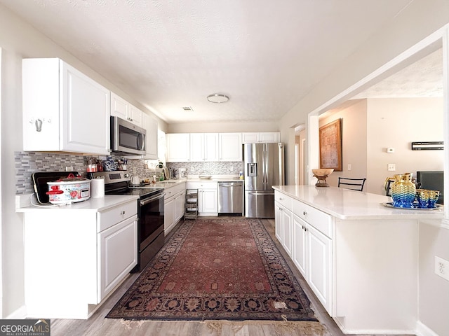 2985 Catalina Dr, Decatur, GA 30032 - kitchen with white cabinetry, light countertops, and appliances with stainless steel finishes