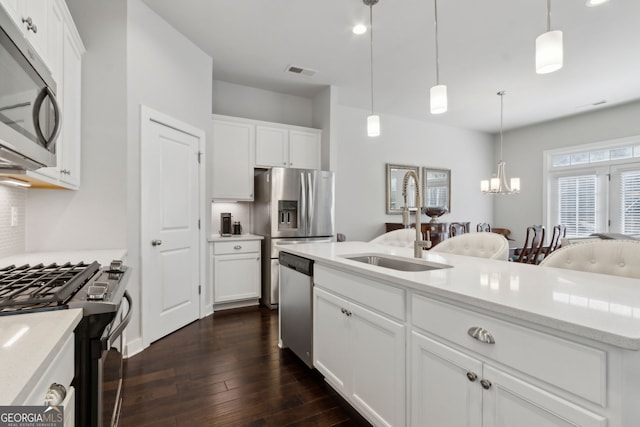 5726 Taylor Way, Sandy Springs, GA 30342 - kitchen with appliances with stainless steel finishes, dark wood finished floors, a chandelier, pendant lighting, and white cabinetry