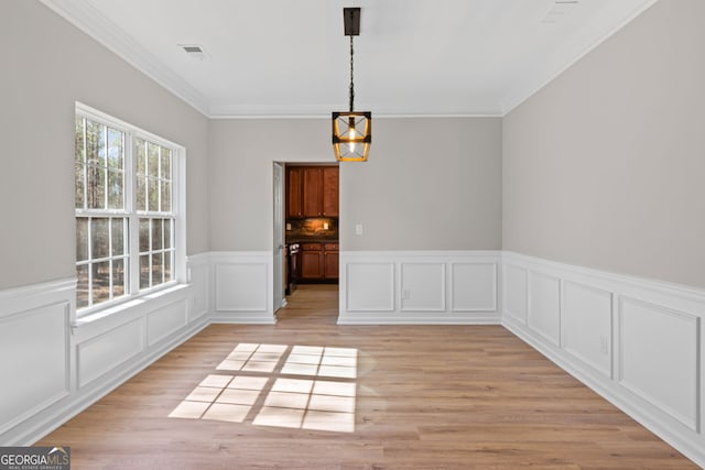 82 Bantry Park Dr, Newnan, GA 30263 - unfurnished dining area featuring a chandelier, wainscoting, ornamental molding, light wood finished floors, and a decorative wall