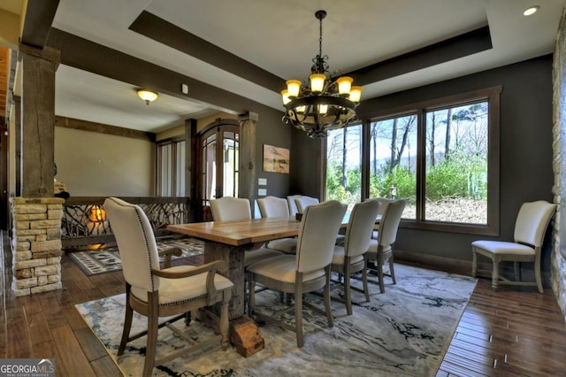 dining room featuring a tray ceiling, hardwood / wood-style floors, and a chandelier