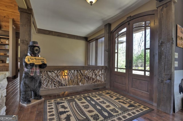 entryway with wood finished floors, french doors, and ornate columns