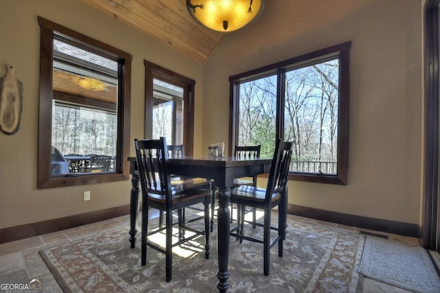 dining room with vaulted ceiling, baseboards, wood ceiling, visible vents, and stone tile flooring
