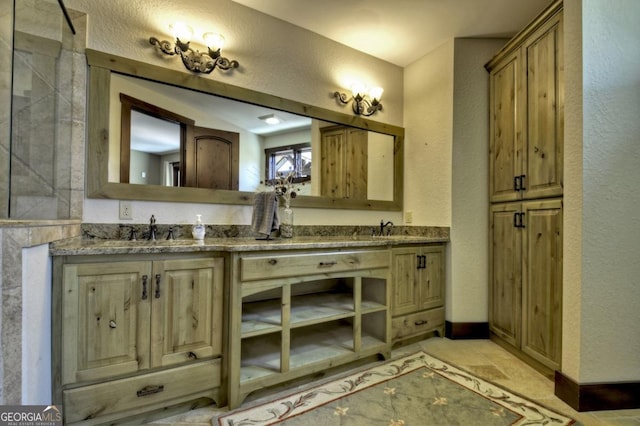 bathroom with double vanity, a textured wall, and a sink