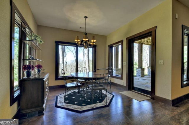 dining space featuring plenty of natural light, baseboards, a notable chandelier, and dark wood-style flooring