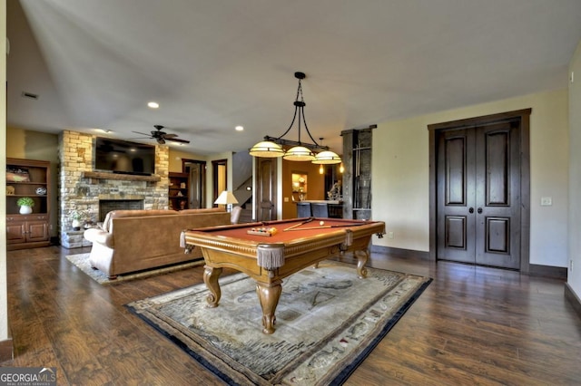 recreation room featuring baseboards, wood finished floors, a ceiling fan, a stone fireplace, and pool table