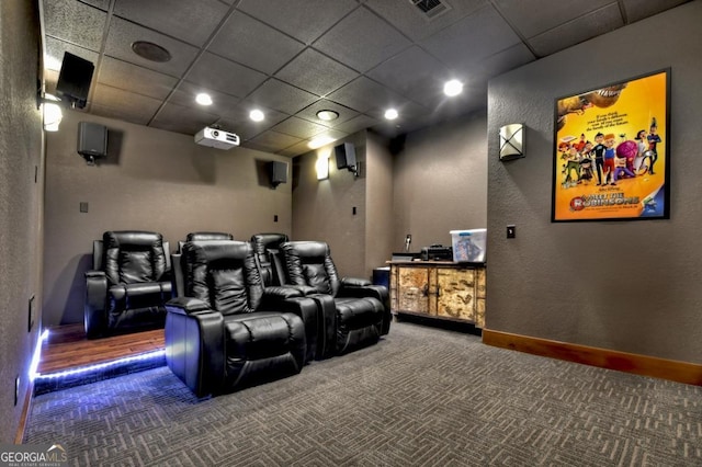 home theater featuring carpet flooring, baseboards, a drop ceiling, and visible vents
