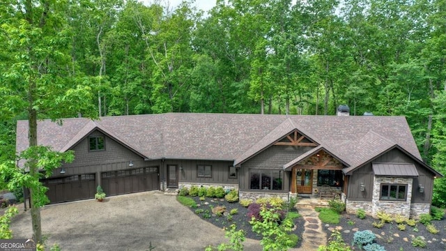 craftsman-style house with driveway, a shingled roof, stone siding, and a garage
