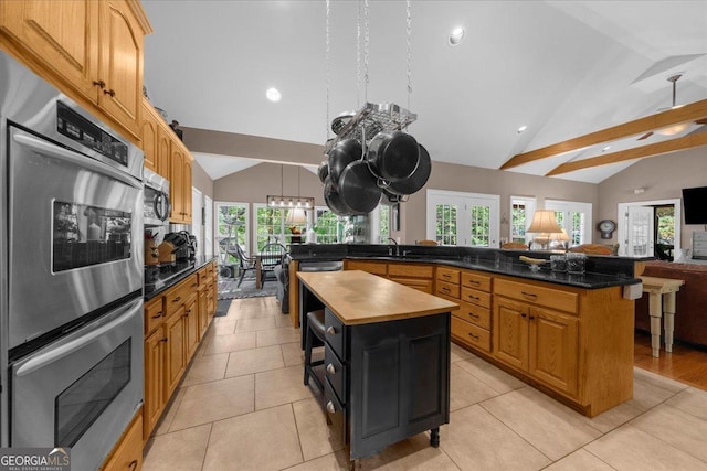kitchen featuring butcher block counters, open floor plan, a center island, recessed lighting, and vaulted ceiling