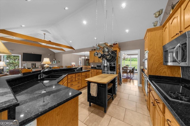 kitchen with open shelves, vaulted ceiling, a spacious island, a sink, and stainless steel microwave