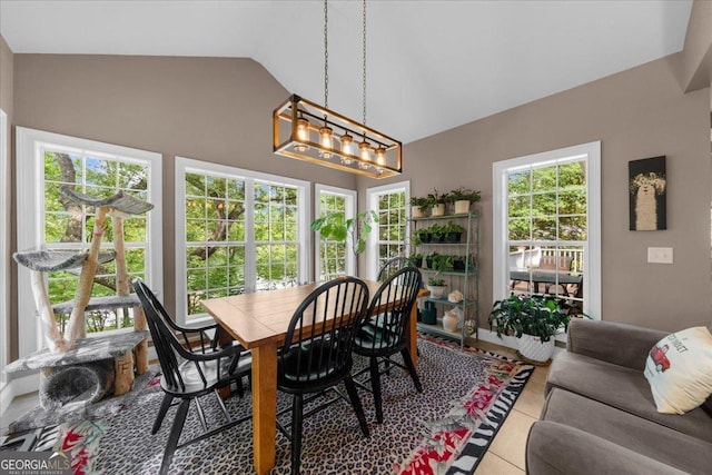 dining room featuring tile patterned flooring, lofted ceiling, and a notable chandelier