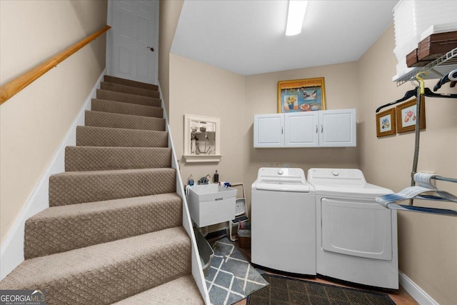 laundry area with a sink, baseboards, cabinet space, and independent washer and dryer