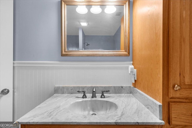 bathroom featuring vanity, a wainscoted wall, and visible vents
