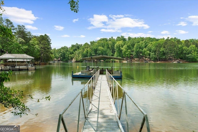view of dock with a water view and a forest view
