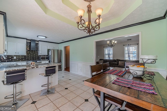 785 Josh Ln, Lawrenceville, GA 30045 - kitchen featuring stainless steel appliances, a chandelier, a textured ceiling, range hood, and white cabinets