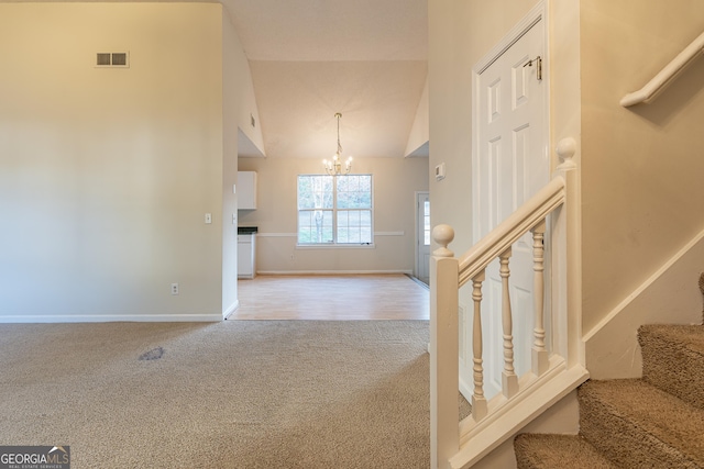 staircase featuring baseboards, carpet floors, visible vents, and a notable chandelier