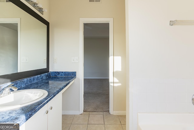 full bathroom with visible vents, baseboards, vanity, a tub to relax in, and tile patterned flooring
