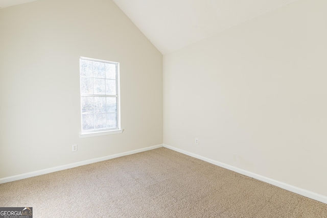carpeted empty room with baseboards and lofted ceiling