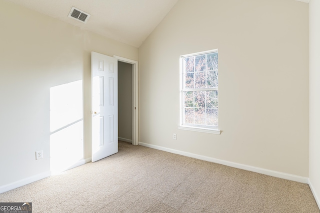 interior space featuring baseboards, visible vents, carpet, and vaulted ceiling