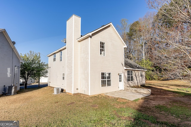 back of house with a patio, a chimney, central AC, and a yard