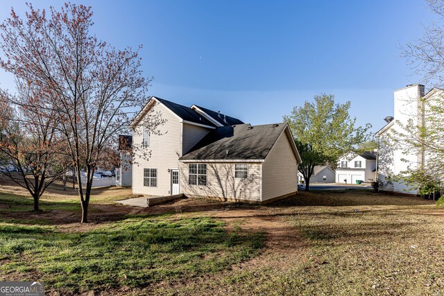 back of house featuring a patio and a yard