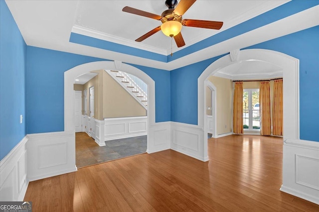 2445 Ridgelake Dr, Villa Rica, GA 30180 - unfurnished room featuring a decorative wall, a tray ceiling, wainscoting, a ceiling fan, and wood finished floors