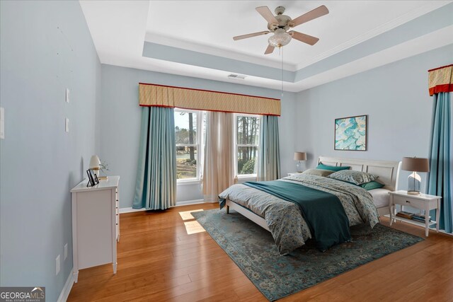 2445 Ridgelake Dr, Villa Rica, GA 30180 - bedroom with a tray ceiling, wood finished floors, crown molding, and ceiling fan