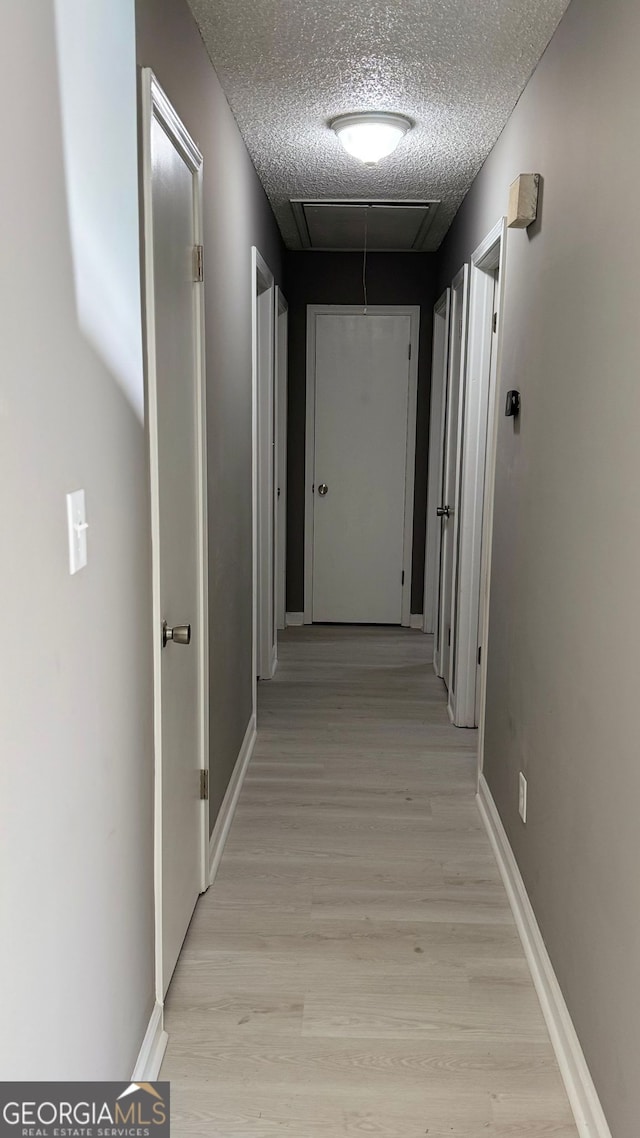1655 Cherry Hill Rd SW, Conyers, GA 30094 - hallway with attic access, baseboards, a textured ceiling, and light wood-type flooring