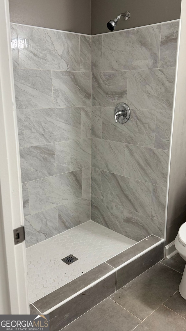 1655 Cherry Hill Rd SW, Conyers, GA 30094 - full bathroom featuring toilet, tile patterned flooring, and a tile shower