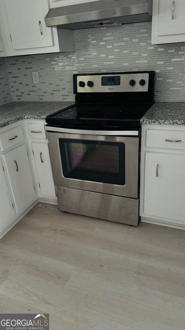 1655 Cherry Hill Rd SW, Conyers, GA 30094 - kitchen featuring stainless steel electric stove, light wood-style floors, extractor fan, and white cabinets