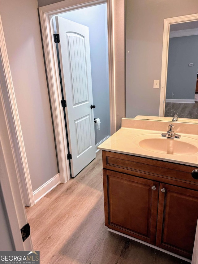 bathroom with vanity, baseboards, and wood finished floors