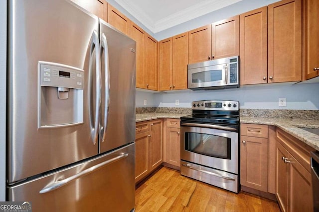 kitchen featuring crown molding, light stone countertops, appliances with stainless steel finishes, brown cabinets, and light wood-type flooring