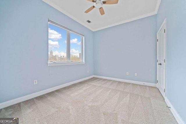 unfurnished room with visible vents, baseboards, ornamental molding, a ceiling fan, and carpet floors