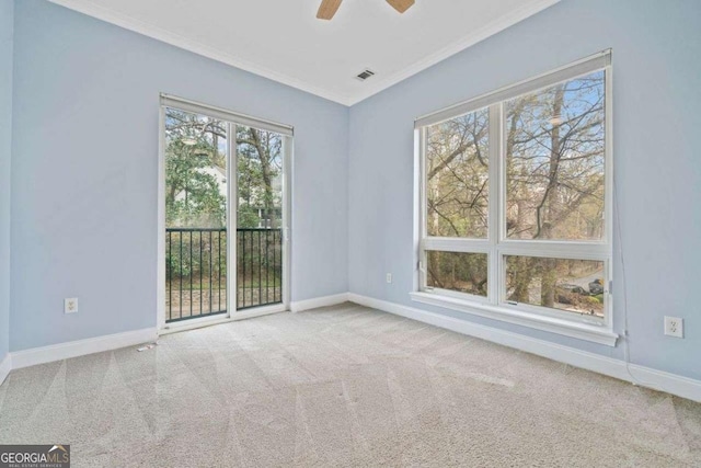 spare room with visible vents, crown molding, carpet, baseboards, and a ceiling fan