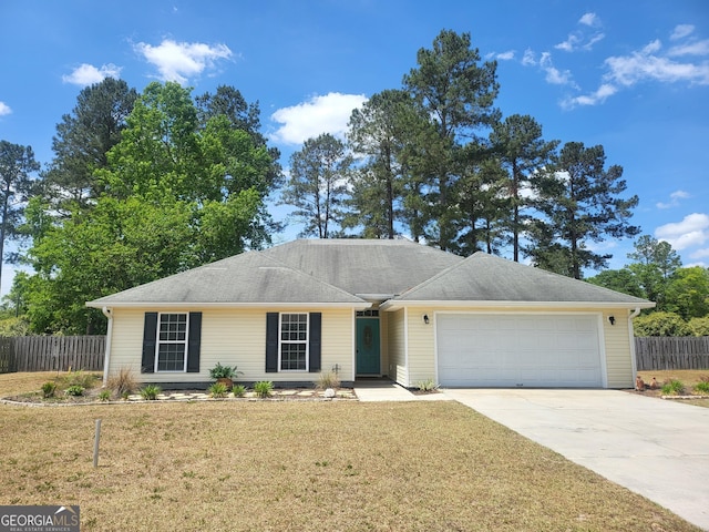 ranch-style home featuring an attached garage, fence, driveway, and a front yard