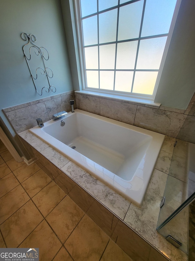 bathroom featuring tile patterned floors and a bath