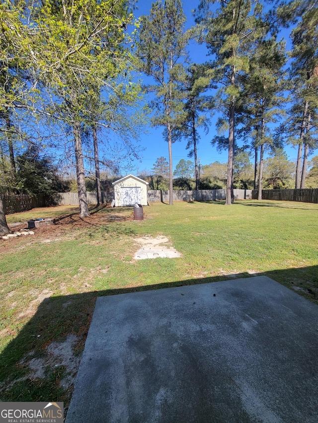 view of yard featuring an outdoor structure, a fenced backyard, a storage unit, and a patio