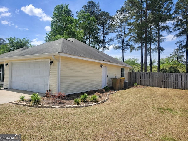view of side of property with fence, an attached garage, cooling unit, a lawn, and driveway