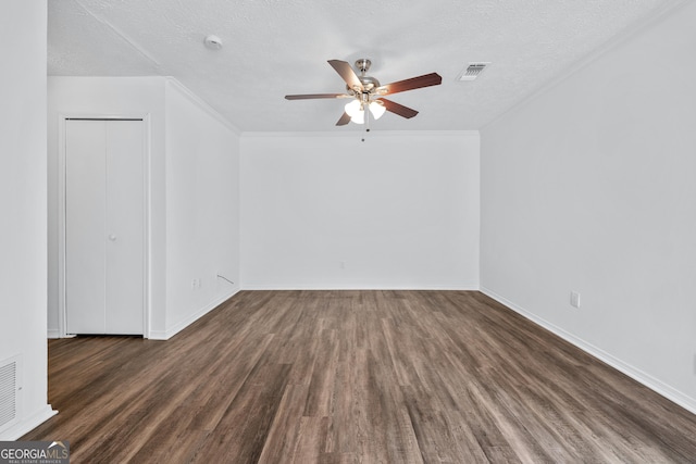 unfurnished room featuring a textured ceiling, visible vents, baseboards, wood finished floors, and a ceiling fan