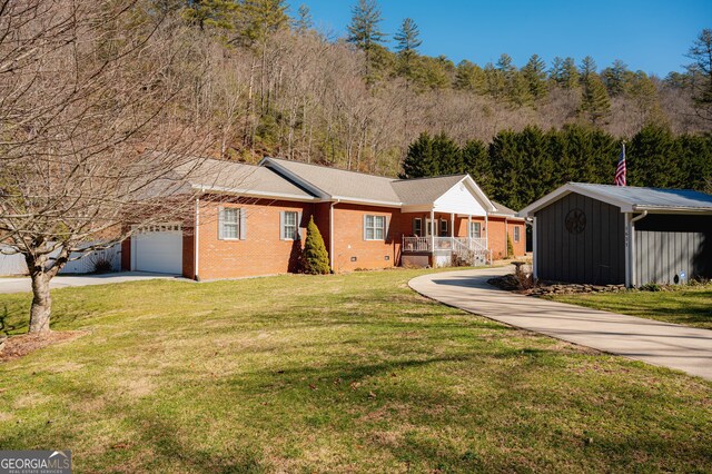 1631 Moody Holw, Hiawassee, GA 30546 - single story home featuring covered porch, a front yard, brick siding, concrete driveway, and an attached garage
