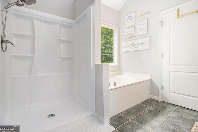 full bathroom featuring tile patterned floors, baseboards, lofted ceiling, a bath, and a stall shower
