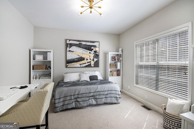 carpeted bedroom with a chandelier, baseboards, and visible vents