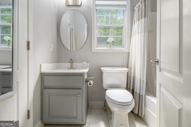 full bathroom featuring vanity, toilet, baseboards, tile patterned floors, and shower / bath combo
